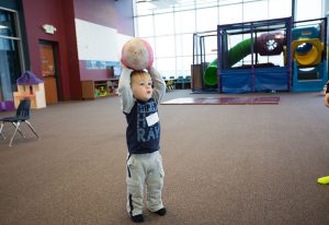 photo of young child with ball in the kid club area