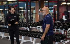 trainer and member in the weight lifting area