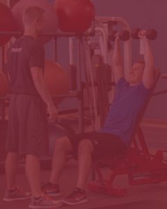 photo of trainer watching man lift small weights - with red overlay